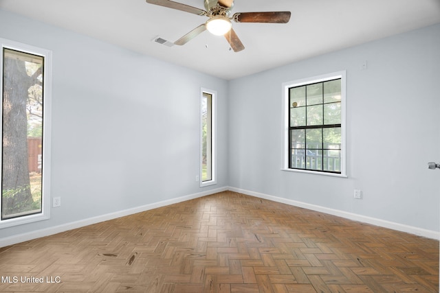 unfurnished room with visible vents, baseboards, and plenty of natural light