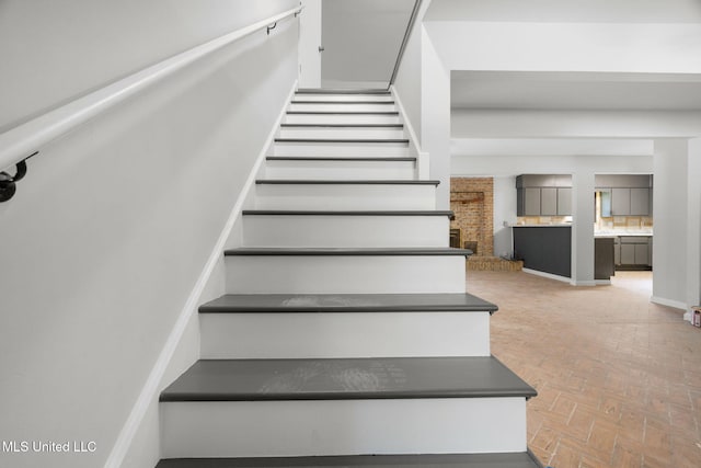 stairs featuring brick floor
