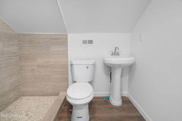 bathroom featuring vaulted ceiling, toilet, wood finished floors, and visible vents
