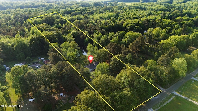 drone / aerial view featuring a wooded view