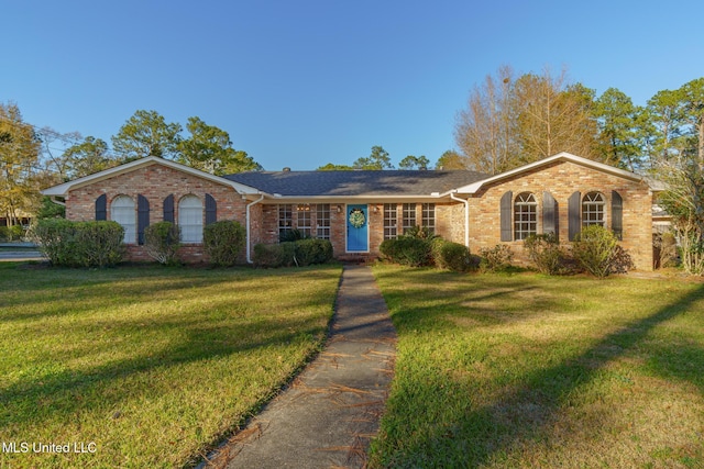 single story home featuring a front yard and brick siding