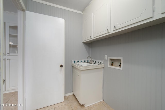 laundry room featuring light tile patterned floors, cabinet space, ornamental molding, hookup for a washing machine, and a sink