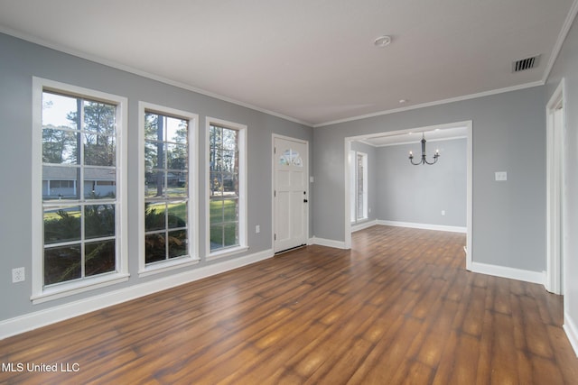 unfurnished living room with baseboards, visible vents, dark wood-style floors, ornamental molding, and an inviting chandelier