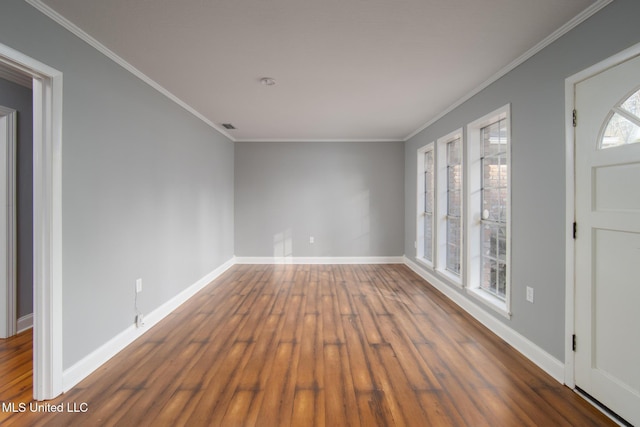 interior space with baseboards, ornamental molding, and wood finished floors