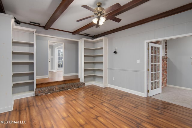 interior space featuring ceiling fan, wood finished floors, visible vents, baseboards, and beam ceiling