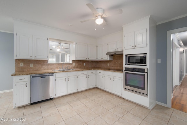 kitchen featuring light tile patterned floors, ornamental molding, a sink, stainless steel appliances, and backsplash