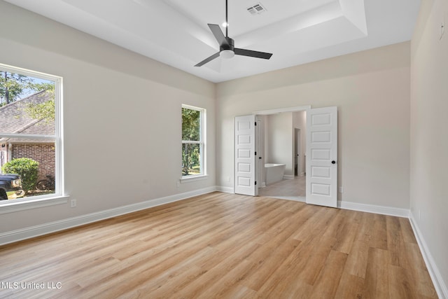 unfurnished bedroom with ensuite bath, light wood-type flooring, and ceiling fan