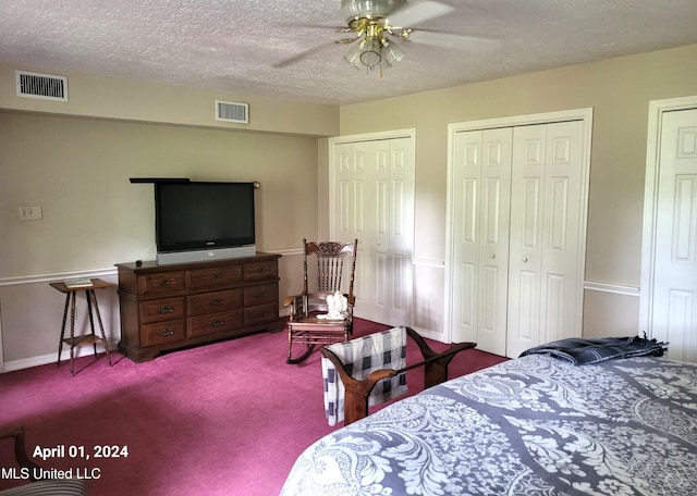 bedroom featuring multiple closets, light carpet, a textured ceiling, and ceiling fan