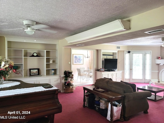 carpeted living room featuring ceiling fan and a textured ceiling