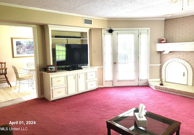 living room featuring carpet, a textured ceiling, and ornamental molding