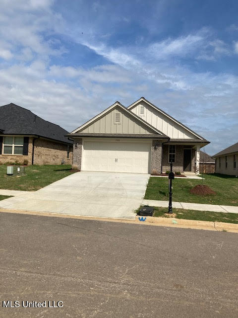 single story home featuring a garage and a front yard