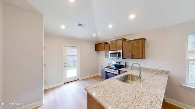 kitchen with plenty of natural light, light wood-type flooring, sink, and appliances with stainless steel finishes