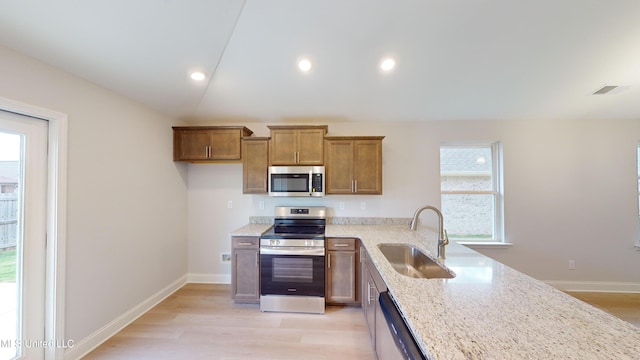 kitchen with a healthy amount of sunlight, sink, stainless steel appliances, and light wood-type flooring