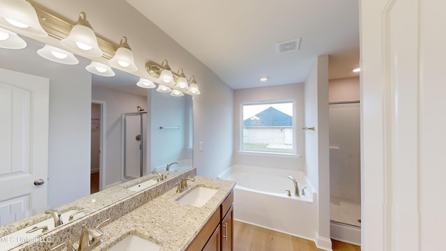 bathroom with vanity, wood-type flooring, and shower with separate bathtub