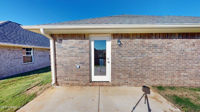 view of exterior entry featuring a patio area