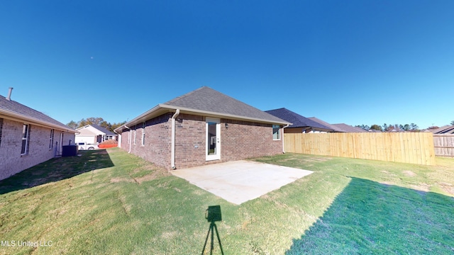 rear view of property featuring a lawn, cooling unit, and a patio