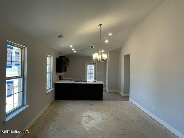 kitchen featuring kitchen peninsula, vaulted ceiling, and plenty of natural light