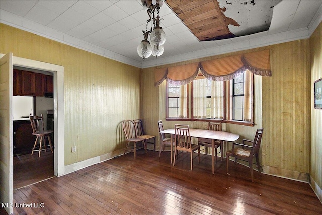 dining room with ornamental molding, baseboards, and hardwood / wood-style flooring