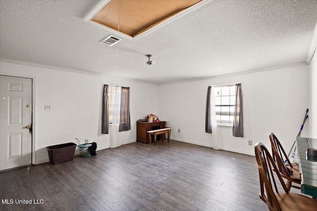 interior space with visible vents, a textured ceiling, crown molding, attic access, and dark wood-style flooring