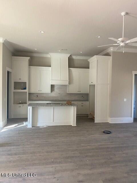 kitchen featuring ornamental molding, white cabinetry, and hardwood / wood-style flooring