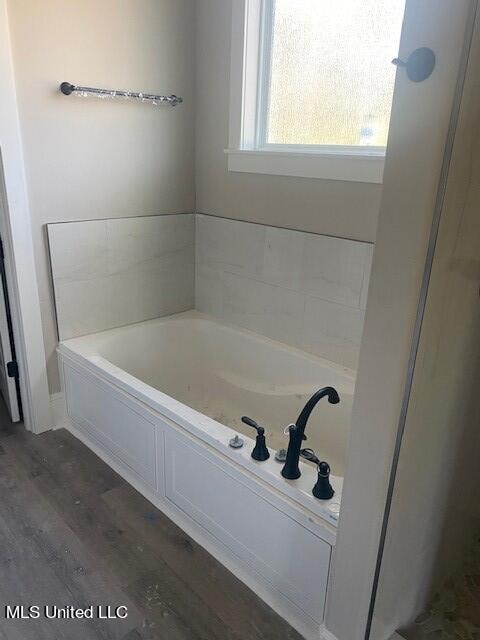 bathroom featuring wood-type flooring and a bathing tub