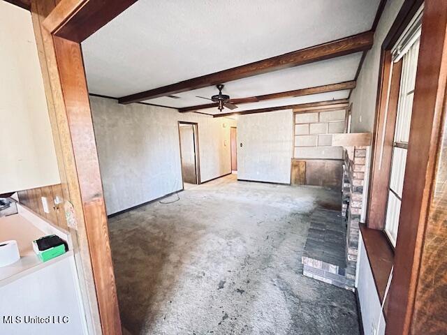 unfurnished living room featuring beam ceiling and ceiling fan