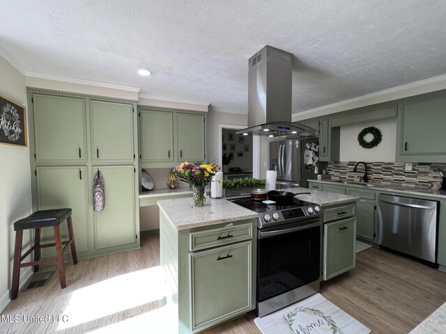 110 Hawks Nest Cv, Brandon, MS 39042 - kitchen with green cabinets, appliances with stainless steel finishes, island exhaust hood, backsplash, and ornamental molding