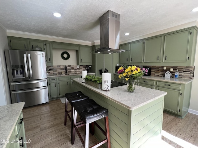110 Hawks Nest Cv, Brandon, MS 39042 - kitchen featuring green cabinets, stainless steel refrigerator with ice dispenser, island exhaust hood, cooktop, and crown molding