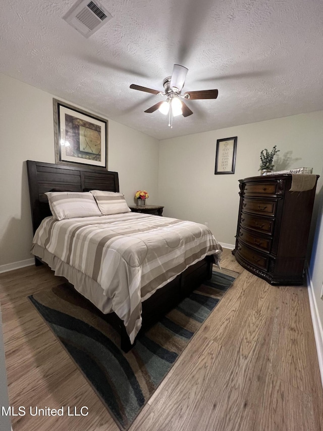 110 Hawks Nest Cv, Brandon, MS 39042 - bedroom featuring wood finished floors, a textured ceiling, and a ceiling fan