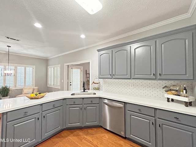 kitchen with gray cabinetry, dishwasher, sink, kitchen peninsula, and decorative light fixtures