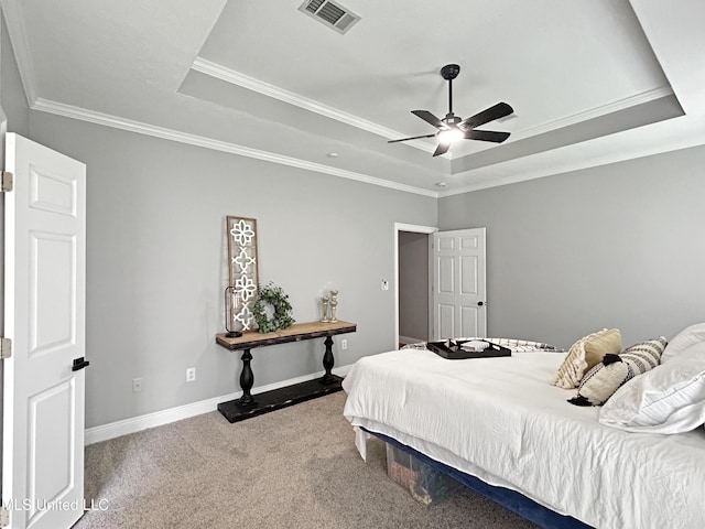 carpeted bedroom with ceiling fan, ornamental molding, and a tray ceiling