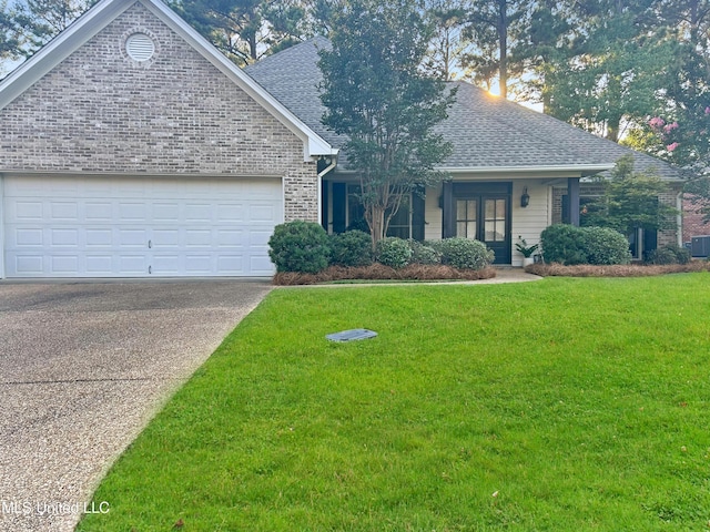 view of front of house featuring central AC unit, a garage, and a front lawn