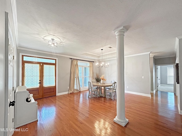 entrance foyer with french doors, a textured ceiling, crown molding, an inviting chandelier, and light hardwood / wood-style floors