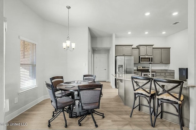 dining room featuring a notable chandelier and light hardwood / wood-style flooring