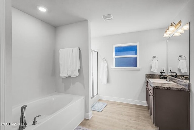 bathroom featuring vanity, hardwood / wood-style flooring, and independent shower and bath