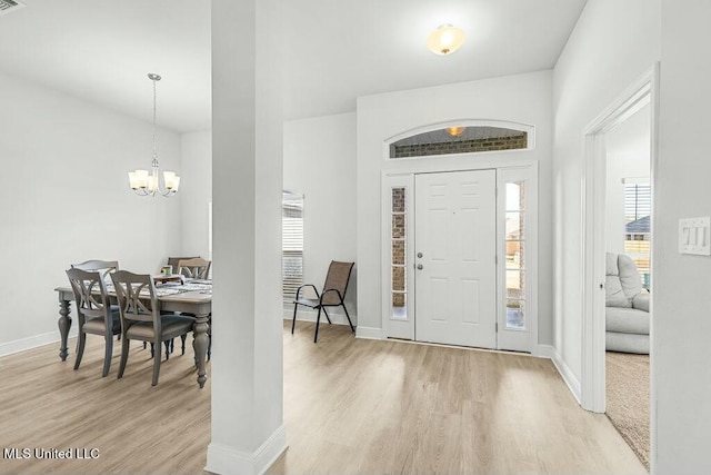 foyer with a notable chandelier and light hardwood / wood-style floors