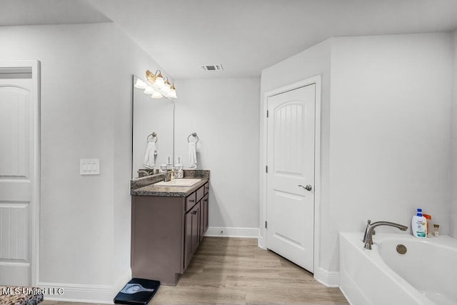 bathroom featuring vanity, wood-type flooring, and a bathing tub