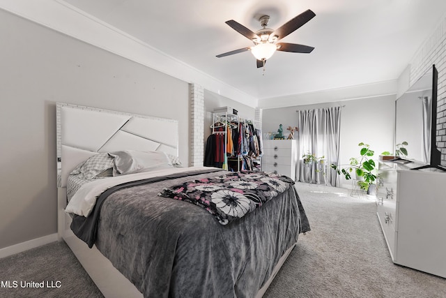 bedroom with carpet, ceiling fan, and brick wall