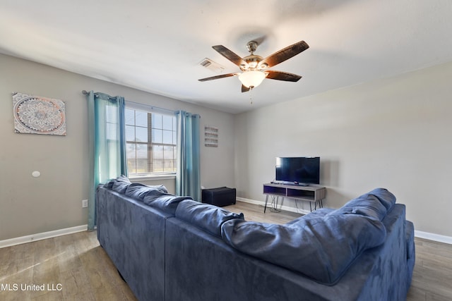 living room featuring ceiling fan and dark hardwood / wood-style flooring