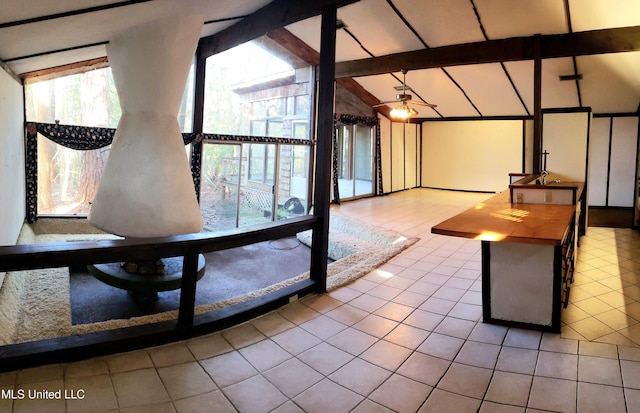 interior space featuring ceiling fan, lofted ceiling with beams, and tile patterned flooring