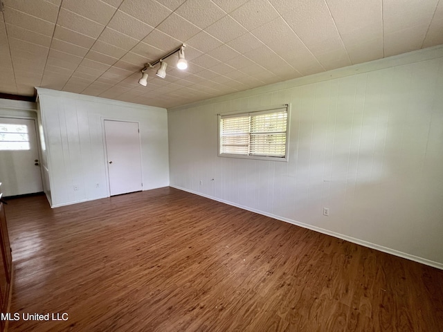 111 E Gresham St, Indianola, MS 38751 - unfurnished bedroom featuring dark wood-type flooring, rail lighting, baseboards, and multiple windows