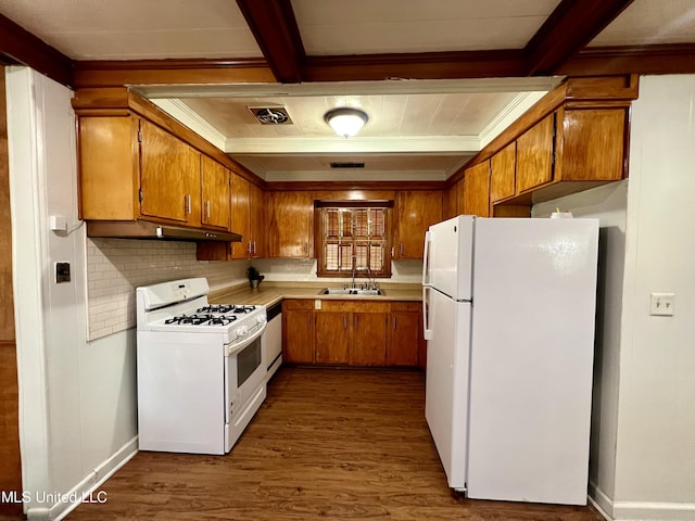 111 E Gresham St, Indianola, MS 38751 - kitchen featuring white appliances, under cabinet range hood, brown cabinetry, and a sink