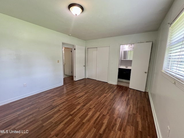 111 E Gresham St, Indianola, MS 38751 - unfurnished bedroom with baseboards, a closet, and dark wood-style floors