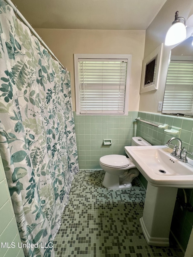 111 E Gresham St, Indianola, MS 38751 - bathroom with a wainscoted wall, a shower with curtain, toilet, and tile walls