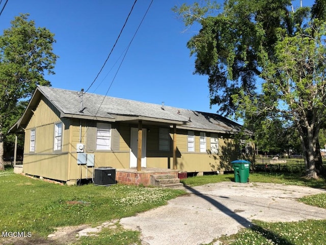 back of property featuring a yard, central AC unit, and covered porch