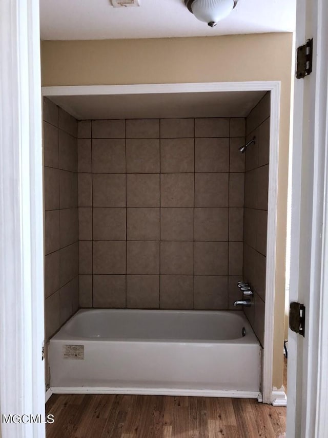 bathroom with tiled shower / bath and hardwood / wood-style flooring