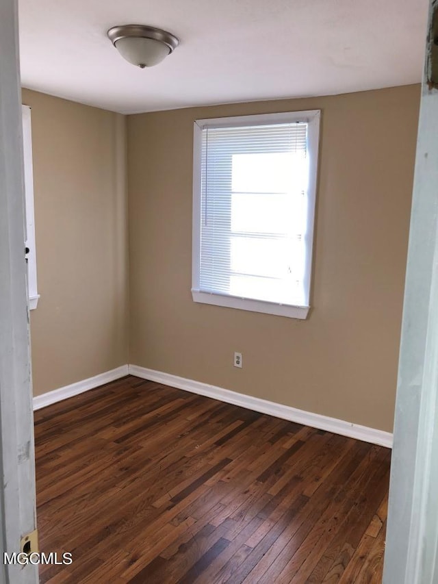 empty room with dark hardwood / wood-style flooring