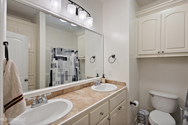 full bath with a shower with shower curtain, double vanity, toilet, and a sink