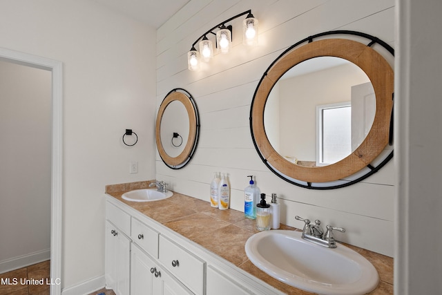 full bath featuring double vanity, wooden walls, and a sink