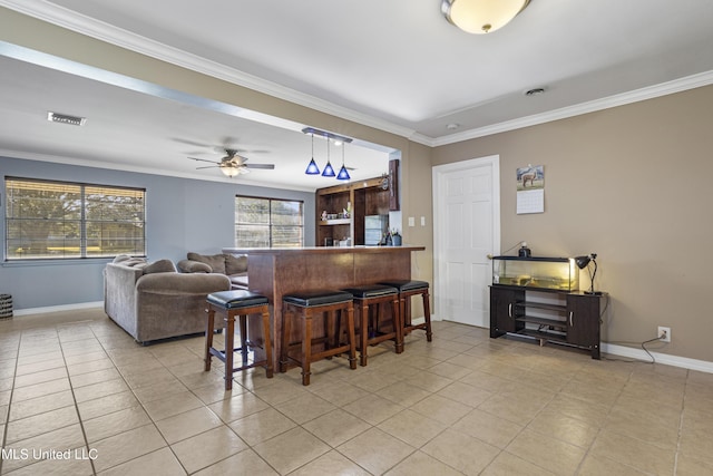 bar featuring ceiling fan, light tile patterned flooring, and crown molding